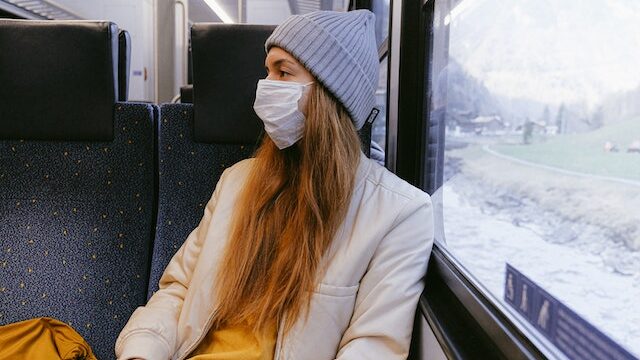 電車に乗るマスクをした女性